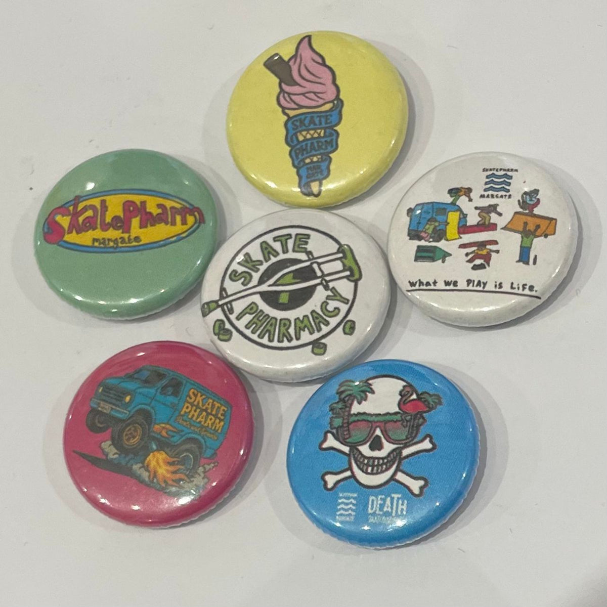 A selection of skateboard pin badges and patches.